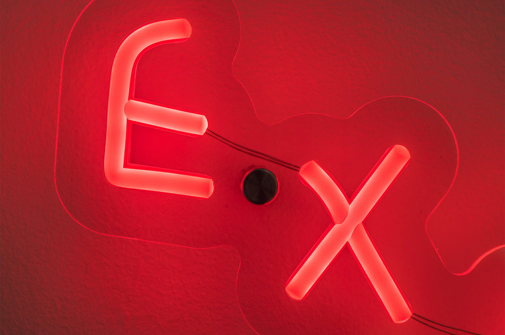 Close-up of EXHAUSTED neon sculpture by Wasted Rita showing illuminated lettering