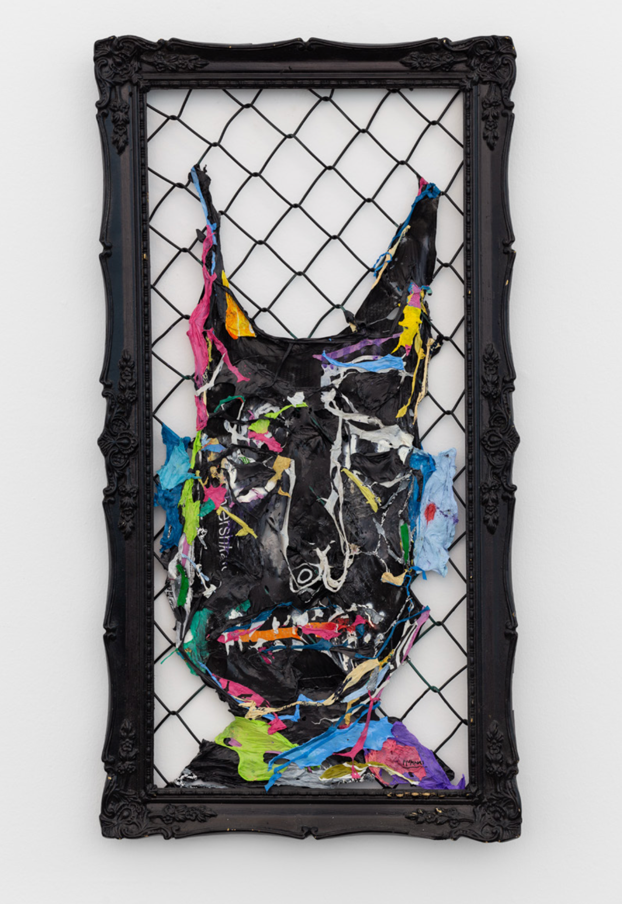 “Crypto Trash” by Fiumani, mixed media wall sculpture made from recycled plastics forming a distorted face inside a black frame with metal mesh