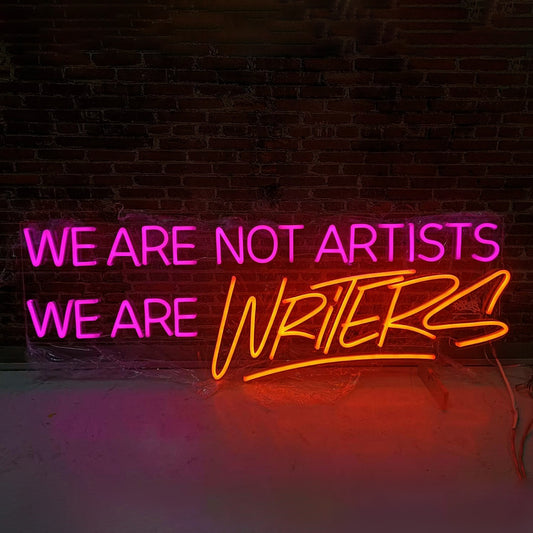 Nasty we are not artist we are writers neon light artwork with pink and orange glowing text