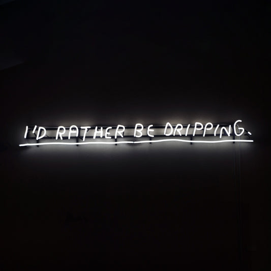 Wasted Rita I’d Rather neon artwork featuring a handwritten illuminated phrase in white neon on a dark background